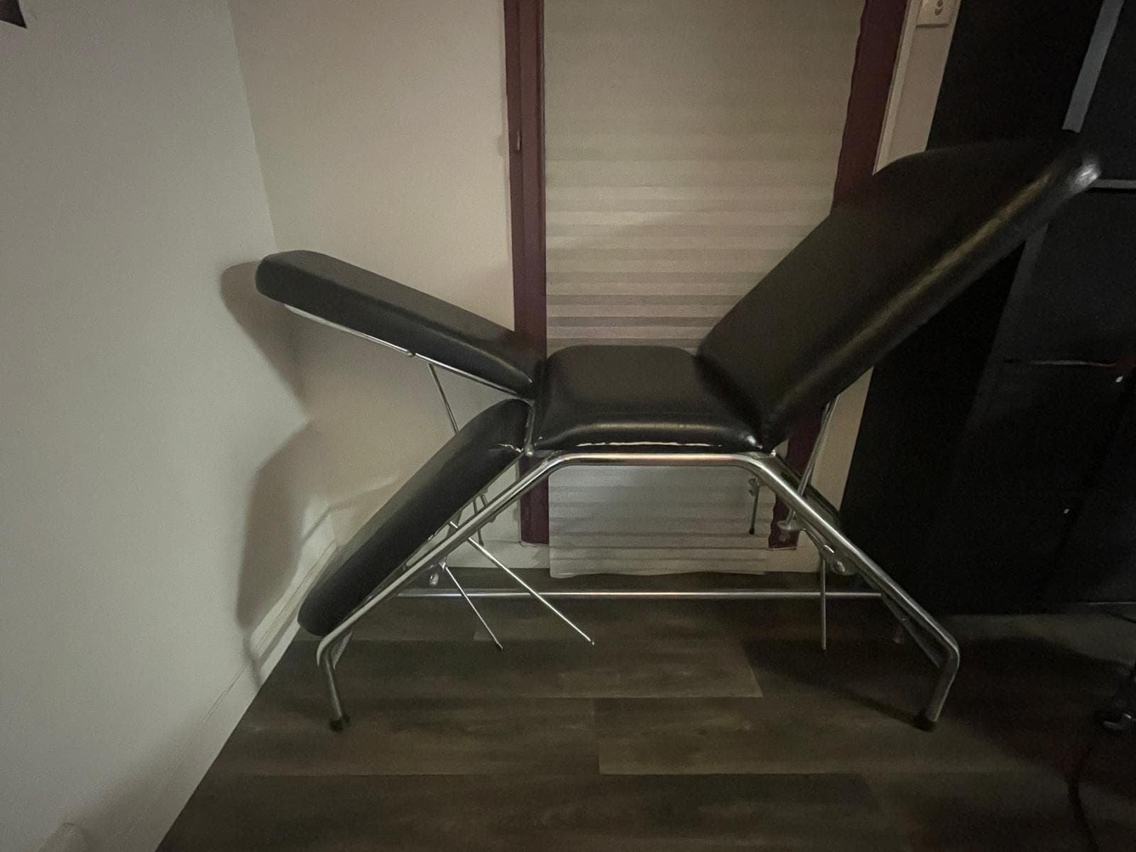 table de posture multipositions, avec une armature métallique chromée et plusieurs plans inclinables indépendamment.